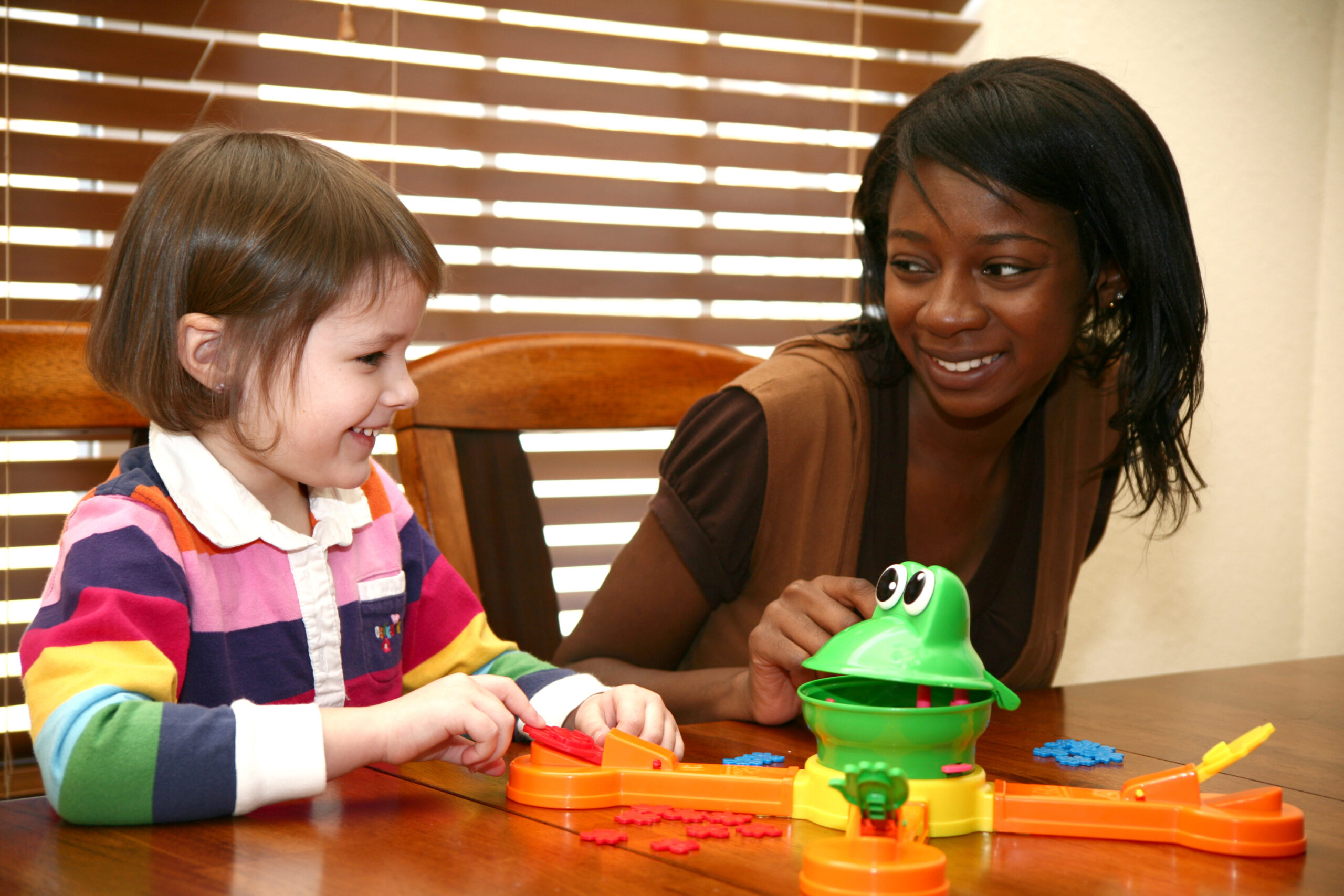 Beautiful african american woman playing games with 5 year old girl.