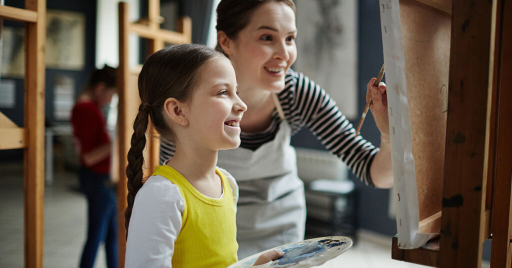 Daycare staff with girl painting