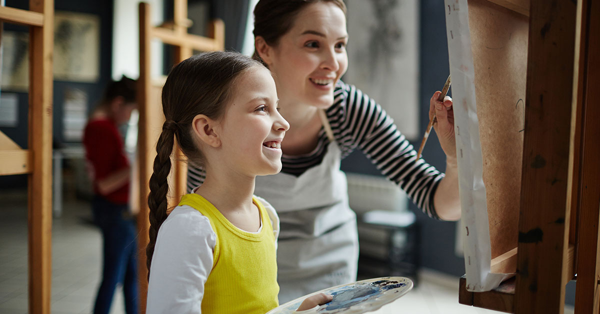 Daycare staff with girl painting