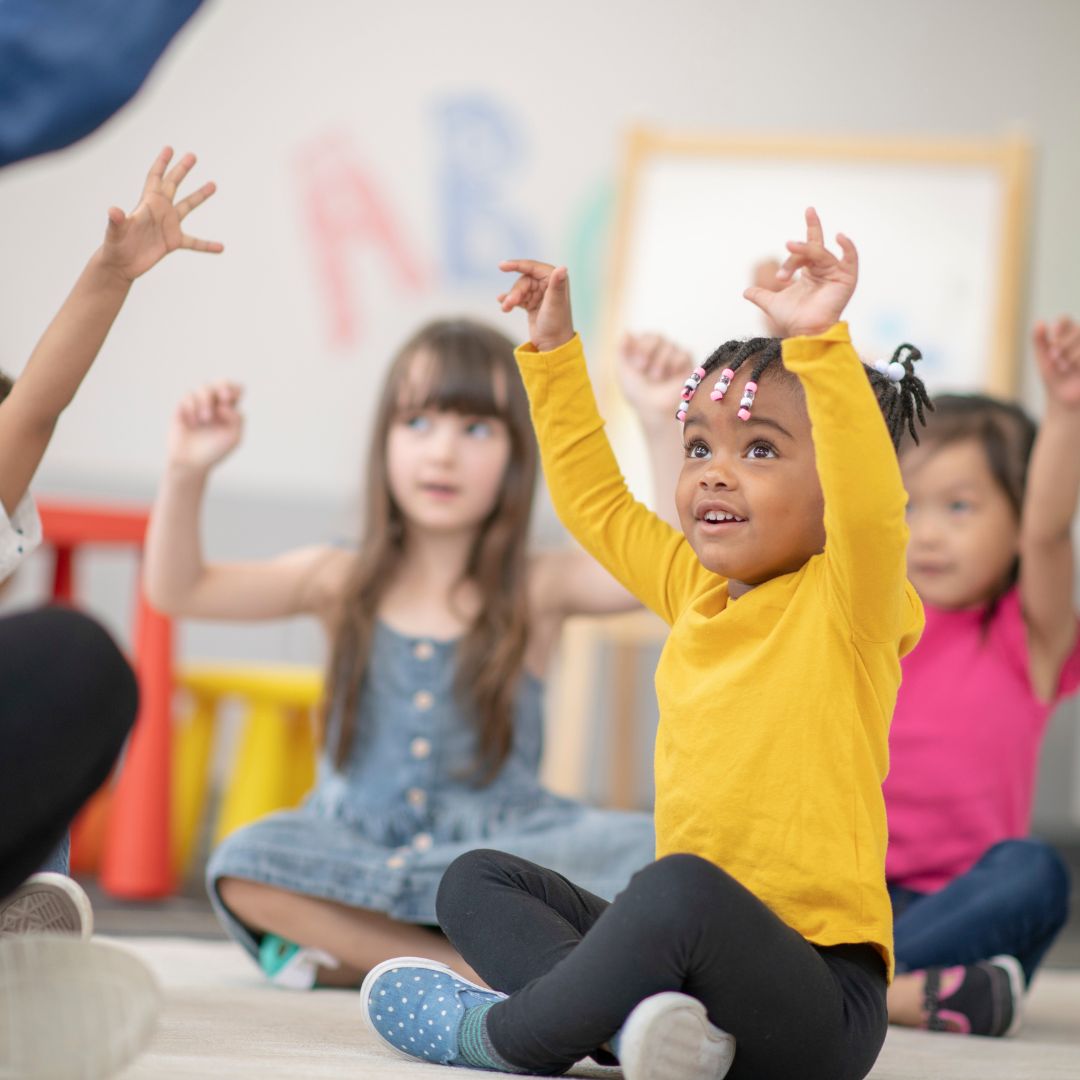 Preschoolers watching teacher and mimicking movements