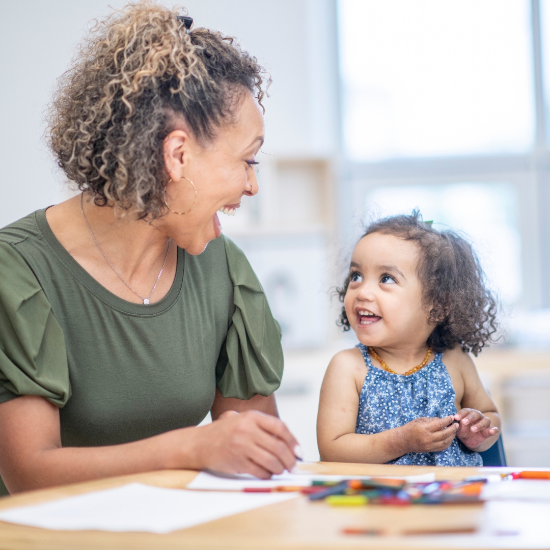 Teacher helping little girl with activity