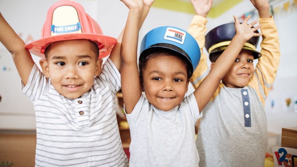 three kids in police hats and fire hats