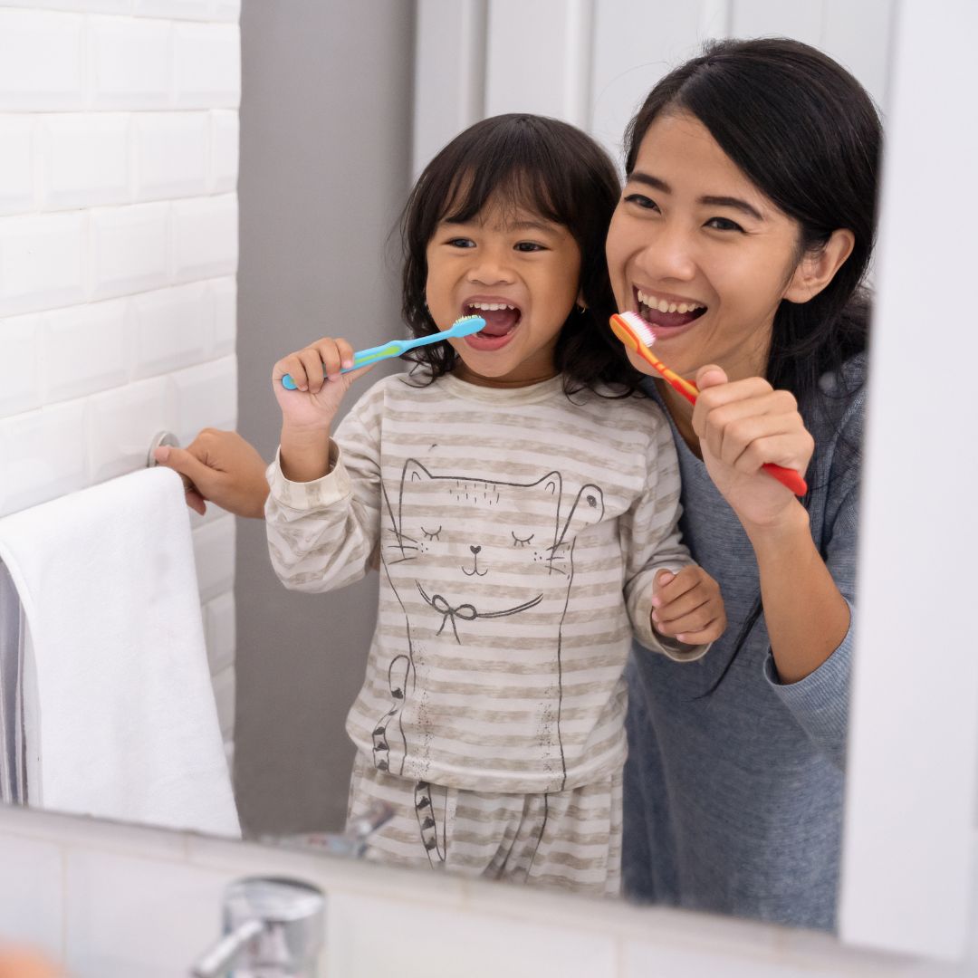 mother and daughter brushing teeth