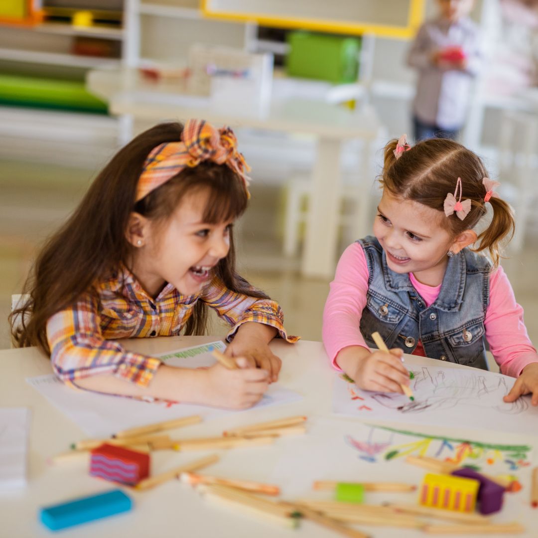 two girls in classroom laughing together