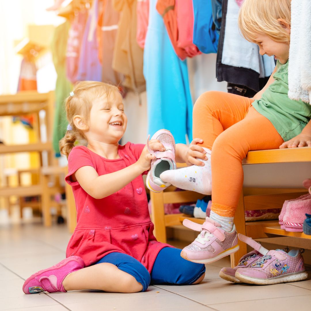 toddlers putting shoes on