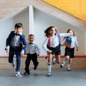 kids in school uniforms run side by side